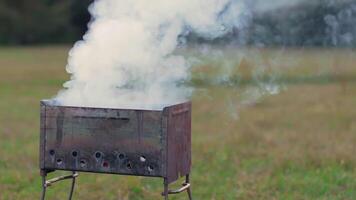 Smoke Comes Out of the Metal Brazier. Grill Cooking Outdoors and Preparing for Barbecue Kebab Grilling. Kindling Coals in the Mangal. Dynamic Shot video