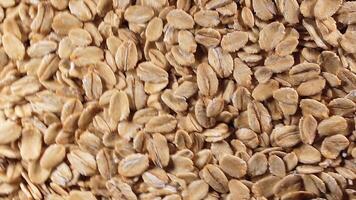 Oat Flakes Background Slowly Rotating Clockwise - Top View. Scattered Dry Oat Flakes. Healthy Breakfast and Diet Eating Ingredients - Angular Rotation Right video