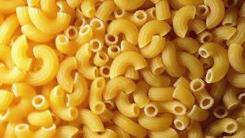 Uncooked Chifferi Rigati Pasta - Top View. Fat and Unhealthy Food. Classic Dry Macaroni, Slowly Rotating Background. Italian Culture and Cuisine. Raw Golden Pasta Texture - RIght Angular Rotation video