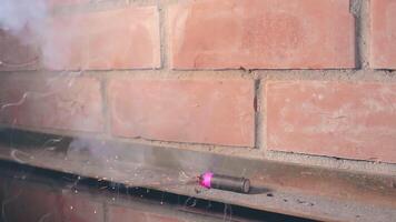 The Petard Was Placed on a Metal Surface by the Hand Than Explode Against a Brick Wall. Many Small Particles Flew in a Different Directions - Static Shot video