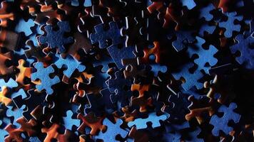 Background of Colored Puzzle Pieces that Slowly Rotating Counterclockwise - Top View. Texture of Incomplete Red and Blue Jigsaw Puzzle with Low Key Light - Left Rotation video