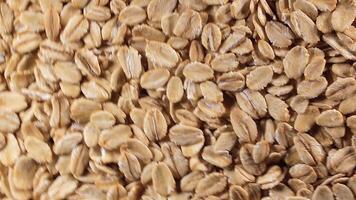 Oat Flakes Background Slowly Rotating Counter-Clockwise - Top View. Scattered Dry Oat Flakes. Healthy Breakfast and Diet Eating Ingredients - Angular Rotation Left video