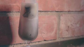 Firecracker Exploaded in a Wineglass Against a Brick Wall. The Blast Wave of a Petard Damaged the Glass and Many Small Fragments of Glass Flew in Different Directions - Static Shot video