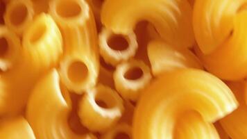 Uncooked Chifferi Rigati Pasta - Top View, Close-Up. Fat and Unhealthy Food. Classic Dry Macaroni, Rotating Background. Italian Culture and Cuisine. Raw Golden Pasta Texture - Left Angular Rotation video