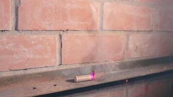 The Petard Was Placed on a Metal Surface by the Hand Than Explode Against a Brick Wall. Many Small Particles Flew in a Different Directions - Static Shot video