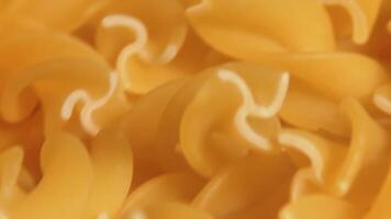 Uncooked Fusilli Pasta Rotating - Macro. Fat and Unhealthy Food. Dry Spiral Macaroni - Close-Up. Italian Culture and Cuisine. Raw Golden Pasta video