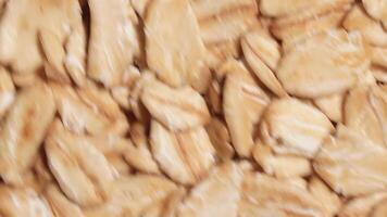 Oat Flakes Background Rotating Counter-Clockwise - Top View, Close-Up. Scattered Dry Oat Flakes. Healthy Breakfast and Diet Eating Ingredients - Angular Rotation Left video