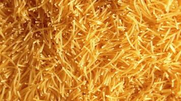 Background of Uncooked Noodles that Rotating Clockwise - Top View, Close-Up. Texture of Dry Vermicelli Turning Around. Raw Pasta with Low Key Light - Right Rotation video