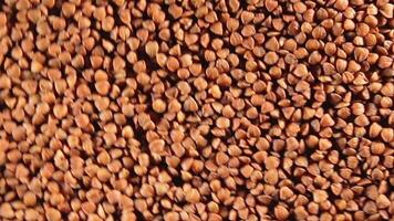 Dry Uncooked Brown Buckwheat Groats, Rotating Clockwise - Top View. Raw Large Buckwheat Grains. Russian, Ukrainian and Belarusian Culture. Rotation Right video