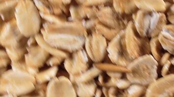 Oat Flakes Background Slowly Rotating Clockwise - Top View, Close-Up. Scattered Dry Oat Flakes. Healthy Breakfast and Diet Eating Ingredients - Angular Rotation Right video