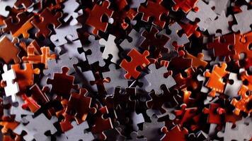 Background of Colored Puzzle Pieces that Rotating Counterclockwise - Top View. Texture of Incomplete Red and Grey Jigsaw Puzzle with Low Key Light - Left Rotation video