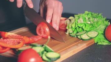 Chef in Blach Uniform is Cutting Vegetables at Home. Cook is Preparing Ingredients for Something Dietary. Healthy Food Concept. Dynamic Closeup Shot video