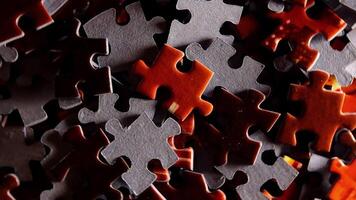 Background of Colored Puzzle Pieces that Slowly Rotating Counterclockwise - Top View, Close-Up. Texture of Incomplete Red and Grey Jigsaw Puzzle with Low Key Light - Left Rotation video