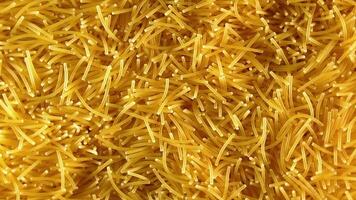 Background of Uncooked Noodles that Slowly Rotating Counterclockwise - Top View, Close-Up. Texture of Dry Vermicelli Turning Around. Raw Pasta with Low Key Light - Left Rotation video