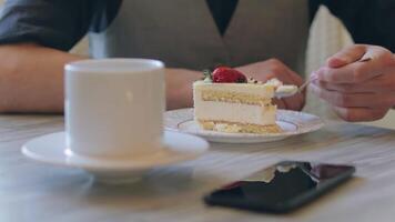 Young Man Eating a Cake With Strawberry and Drinking Tea. Office Worker Has a Break. Cafe Dessert Concept. Close-Up View, Dynamic Shot video
