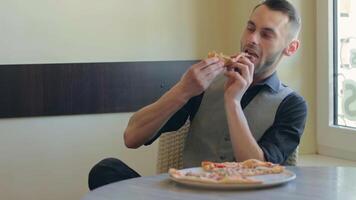 Handsome Young Man Eating Pizza in Pizzeria Cafe. Youthfull Customer or Office Worker Has a Break. Close-Up View, Dynamic Shot video
