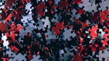 Background of Colored Puzzle Pieces that Slowly Rotating Clockwise - Top View. Texture of Incomplete Red and Grey Jigsaw Puzzle with Low Key Light - Right Rotation video