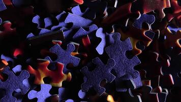 Background of Colored Puzzle Pieces that Slowly Rotating Counterclockwise - Top View, Close-Up. Texture of Incomplete Red and Blue Jigsaw Puzzle with Low Key Light - Right Rotation video