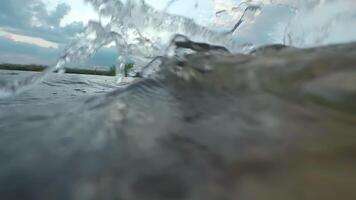 Over and Under River Surface with Water Reflections - Low Angle View. Underwater Split View with Waves at Sunny Summer Day - Super Slow Motion video