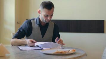 Handsome Young Man is Writing a Document in Pizzeria Cafe. Office Employee Has a Break. Middle Close-Up View, Dynamic Shot video