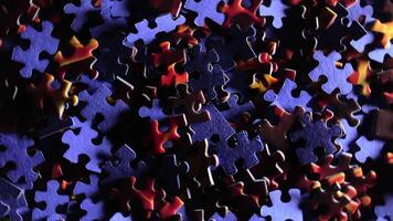 Background of Colored Puzzle Pieces that Rotating Counterclockwise - Top View. Texture of Incomplete Red and Blue Jigsaw Puzzle with Low Key Light - Left Rotation video