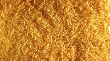 Background of Uncooked Golden Noodles that Rotating Clockwise - Top View. Texture of Dry Vermicelli Turning Around. Raw Pasta with Low Key Light - Right Rotation video