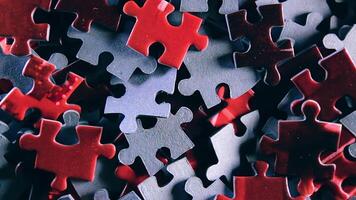 Background of Colored Puzzle Pieces that Slowly Rotating Clockwise - Top View, Close-Up. Texture of Incomplete Red and Grey Jigsaw Puzzle - Right Rotation video
