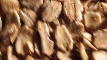 Oat Flakes Background Rotating Counter-Clockwise - Top View, Close-Up, Low Key Light. Scattered Dry Oat Flakes. Healthy Breakfast and Diet Eating Ingredients - Angular Rotation Left video