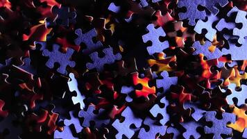 Background of Colored Puzzle Pieces that Slowly Rotating Clockwise - Top View. Texture of Incomplete Red and Blue Jigsaw Puzzle with Low Key Light - Right Rotation video