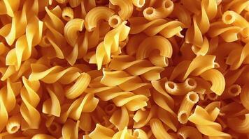 Uncooked Fusilli and Chifferi Rigati Pasta - Top View, Close-Up, Low Key. Fat and Unhealthy Food. Classic Dry Macaroni, Slowly Rotating Background. Raw Different Macaroni Pasta Texture - Rotate Right video