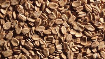 Oat Flakes Background Slowly Rotating Clockwise - Top View, Low Key Light. Scattered Dry Oat Flakes. Healthy Breakfast and Diet Eating Ingredients - Angular Rotation Right video