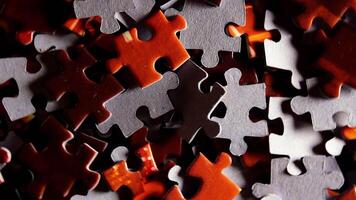 Background of Colored Puzzle Pieces that Rotating Clockwise - Top View, Close-Up. Texture of Incomplete Red and Grey Jigsaw Puzzle with Low Key Light - Right Rotation video