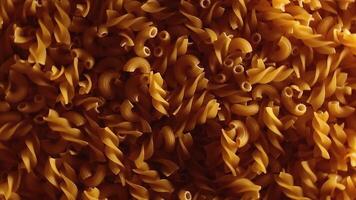Uncooked Fusilli and Chifferi Rigati Pasta - Top View, Low Key Light. Fat and Unhealthy Food. Classic Dry Macaroni, Slowly Rotating Background. Raw Different Macaroni Pasta Texture - Rotate Left video