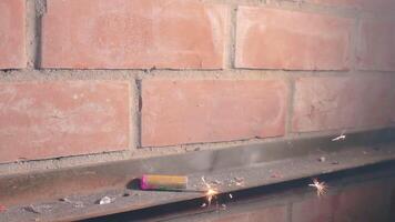 The Petard Was Placed on a Metal Surface by the Hand Than Explode Against a Brick Wall. Many Small Particles Flew in a Different Directions - Static Shot video