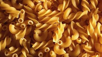 Uncooked Fusilli and Chifferi Rigati Pasta - Top View, Close-Up, Low Key. Fat and Unhealthy Food. Classic Dry Macaroni, Rotating Background. Raw Different Macaroni Pasta Texture - Rotate Left video