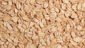 Oat Flakes Background Slowly Rotating Counter-Clockwise - Top View. Scattered Dry Oat Flakes. Healthy Breakfast and Diet Eating Ingredients - Angular Rotation Left video