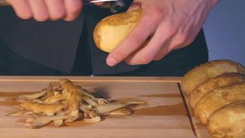 Man in Black Clothing is Peeling Potato and Preparing Ingredients for Cooking Dinner video