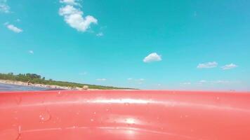 Sea Surface with Waves at Sunny Summer Day. Camera Placed on Red Flying Disc, the View from the Boat Swaying on the Waves - Slow Motion video