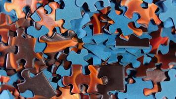 Background of Colored Puzzle Pieces that Rotating Counterclockwise - Top View, Close-Up. Texture of Incomplete Red and Blue Jigsaw Puzzle - Left Rotation video