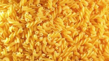 Uncooked Fusilli and Chifferi Rigati Pasta - Top View. Fat and Unhealthy Food. Classic Dry Macaroni, Rotating Background. Raw Different Macaroni Pasta Texture - Rotate Left video