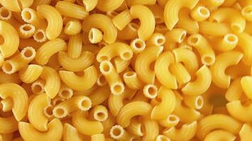 Uncooked Chifferi Rigati Pasta - Top View. Fat and Unhealthy Food. Classic Dry Macaroni, Slowly Rotating Background. Italian Culture and Cuisine. Raw Golden Pasta Texture - Left Angular Rotation video