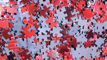 Background of Colored Puzzle Pieces that Slowly Rotating Clockwise - Top View. Texture of Incomplete Red and Grey Jigsaw Puzzle - Right Rotation video