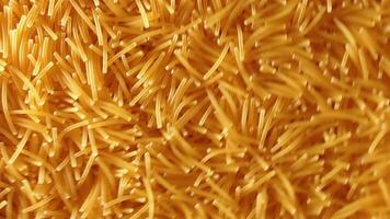 Background of Uncooked Noodles Rotating Counter-Clockwise - Top View, Angular Rotation. Texture of Dry Vermicelli Turning Around. Raw Pasta with Low Key Light - Left Rotation video