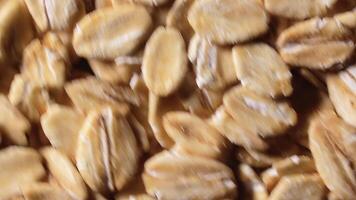 Oat Flakes Background Rotating Clockwise - Top View, Close-Up, Low Key Light. Scattered Dry Oat Flakes. Healthy Breakfast and Diet Eating Ingredients - Angular Rotation Right video