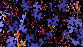Background of Colored Puzzle Pieces that Rotating Counterclockwise - Top View. Texture of Incomplete Red and Blue Jigsaw Puzzle with Low Key Light - Left Rotation video