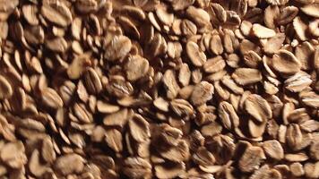 Oat Flakes Background Rotating Clockwise - Top View, Low Key Light. Scattered Dry Oat Flakes. Healthy Breakfast and Diet Eating Ingredients - Angular Rotation Right video