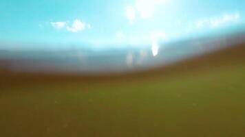 Over and Under Sea Surface with the Lights of the Sun Through the Water. Underwater Split View with Sea Waves at Sunny Summer Day - Slow Motion video