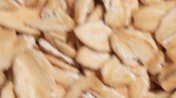 Oat Flakes Background Rotating Clockwise - Top View, Close-Up. Scattered Dry Oat Flakes. Healthy Breakfast and Diet Eating Ingredients - Angular Rotation Right video