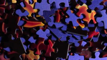 Background of Colored Puzzle Pieces that Rotating Counterclockwise - Top View, Close-Up. Texture of Incomplete Red and Blue Jigsaw Puzzle with Low Key Light - Left Rotation video