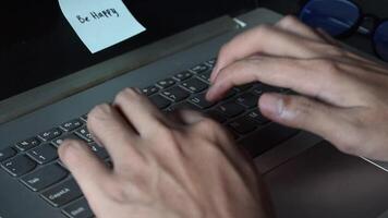 fechar acima homem trabalhando com isto computador portátil e pegue motivação pegajoso Nota com palavra estar feliz video